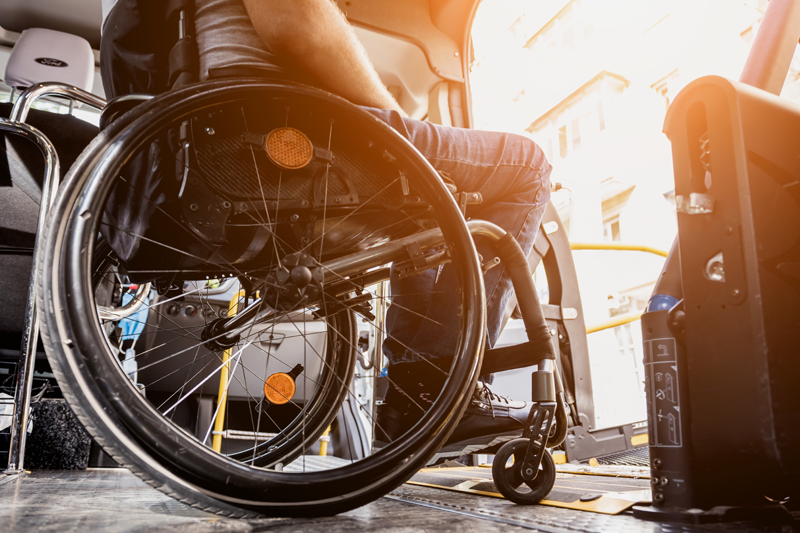 A person in a wheelchair waiting for an accessible lift on a bus.