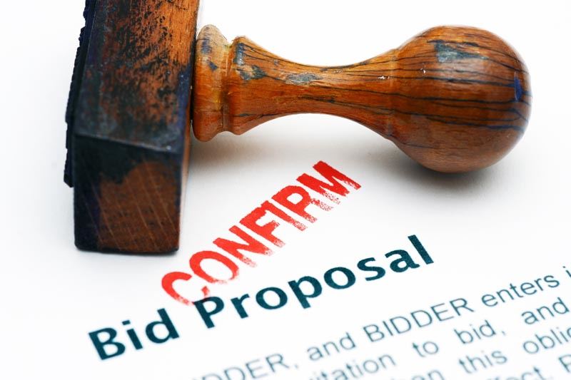 A confirmed stamp on a piece of paper that reads: Bid Proposal.