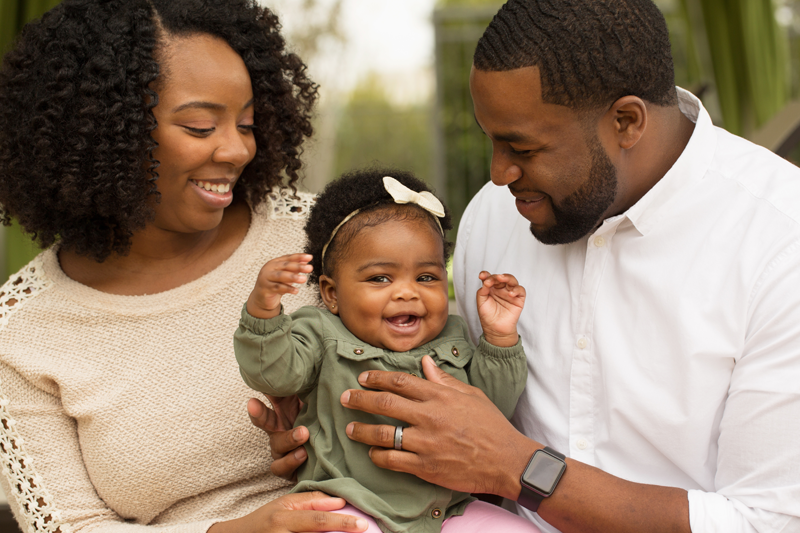Mother and father holding a baby.
